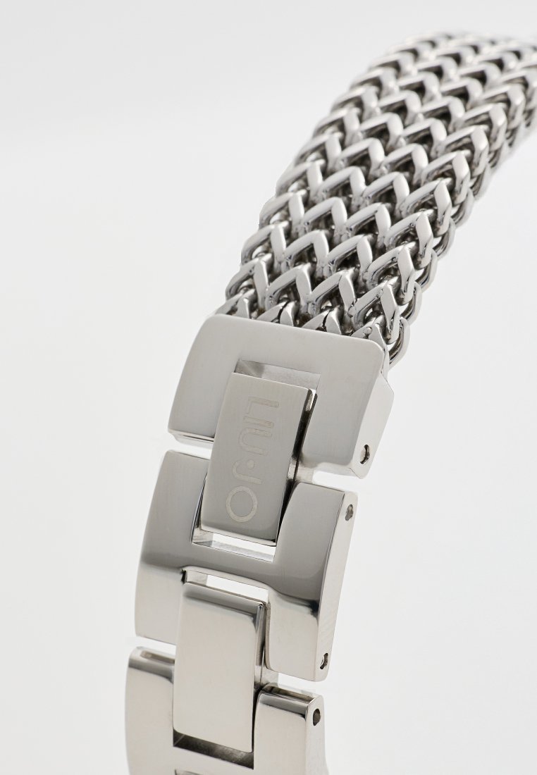 Metalen gaas horlogeband met zilverkleurige afwerking, voorzien van een gladde sluiting en rechthoekige schakels. Strak ontwerp met een egale textuur.