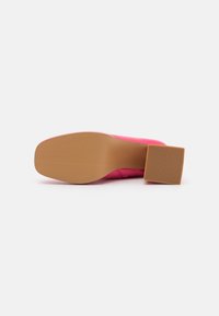 Růžová vysoká bota na podpatku se čtvercovým blokovým podpatkem a gumovou podrážkou. Svršek je vyroben z hladkého syntetického materiálu s minimalistickým designem.