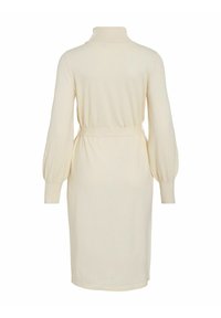 Robe en tricot crème avec un col haut, de longues manches ballon, une ceinture à la taille et une coupe arrivant au genou. Texture lisse, design simple.