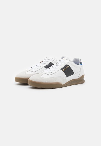Weiße Sneaker mit einer Wildleder-Spitze, schwarzem Seitenstreifen und goldenem Logo. Ausgestattet mit flachen Schnürsenkeln und einer Sohle aus Gummi. Mit blauen Akzenten versehen.