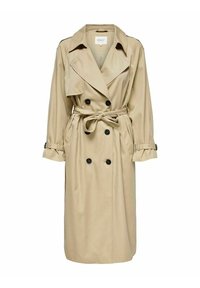 Trench-coat long beige avec boutons noirs double boutonnage, taille ceinturée, larges revers et sangles ajustables aux poignets.