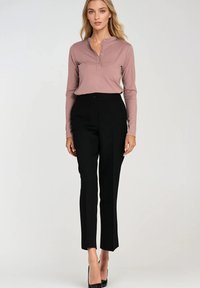 Długi rękaw w kolorze mauve koszula typu henley z trzema guzikami, zestawiona z dopasowanymi czarnymi spodniami o gładkiej teksturze i slim fit.