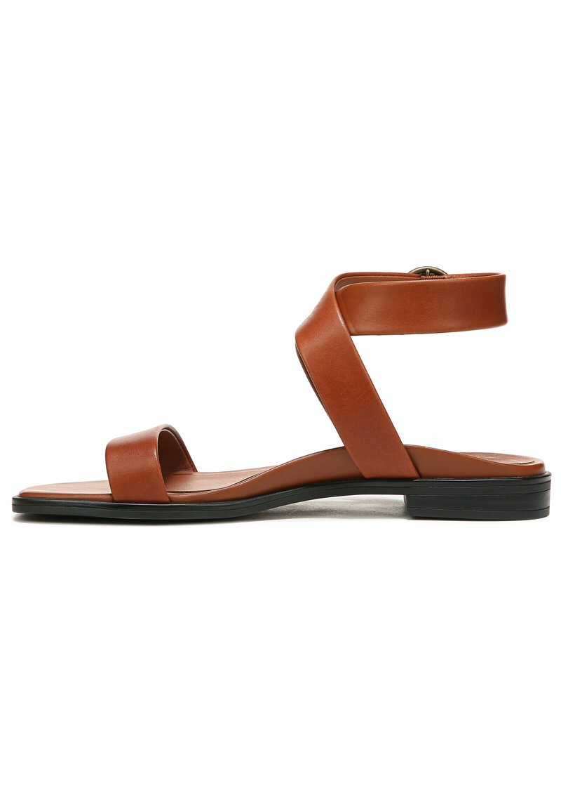 Brown leather sandal with two broad straps and a closed heel. Features a flat black sole and a side buckle for adjustment.