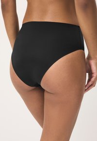 Črni plavalni spodnji del z visokim pasom, gladke teksture in minimalističnega oblikovanja, z brezšivnim rezom za udobje in vsestranskost pri oblikovanju.
