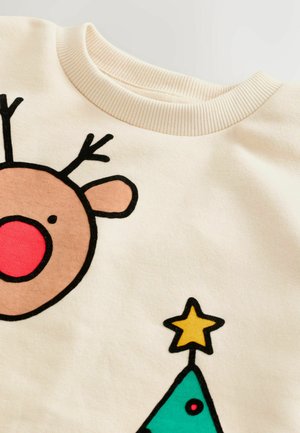 Vaalean kerma sweatshirt, jossa on sarjakuvamainen poro punaisella nenällä, mustalla ääriviivalla ja vihreä jouluaito, jonka päällä on keltainen tähti.