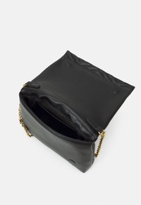 Czarna skórzana torebka na łańcuszkowym pasku, z pikowanym wierzchem i jedną przegrodą. Wnętrze wyłożone czarną podszewką, bez widocznych kieszeni.