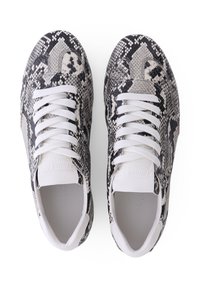 Sneaker aus schwarz-weißem Schlangen-Muster mit einer glatten weißen Gummisohle und weißen Schnürsenkeln.