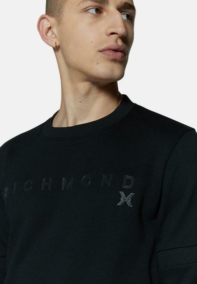 Felpa nera con stampa del logo testurizzata. Design semplice a girocollo con tessuto liscio e maniche aderenti.