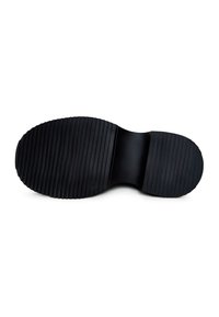 Suela de zapato de goma negra con estrías horizontales, área central lisa y forma redondeada. Texturizada para ofrecer tracción y durabilidad.