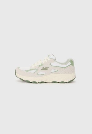 Athletic sneakers in light cream with green accents, featuring mesh and suede materials, rounded toe, and textured rubber sole.