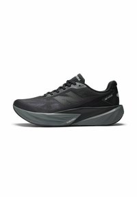 Schwarzer Sport Schuh mit Mesh-Obermaterial, strukturierten Details und erheblichem grauen Zwischensohleneinsatz. Verfügt über Schnürsenkel und eine Marke an der Seite und Zunge.