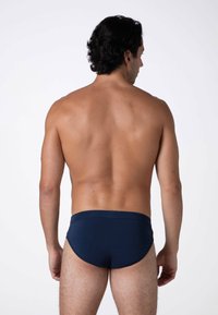 Slip da bagno blu navy con un tessuto liscio e elastico e una cintura larga. Presenta un design semplice e aerodinamico senza motivi.