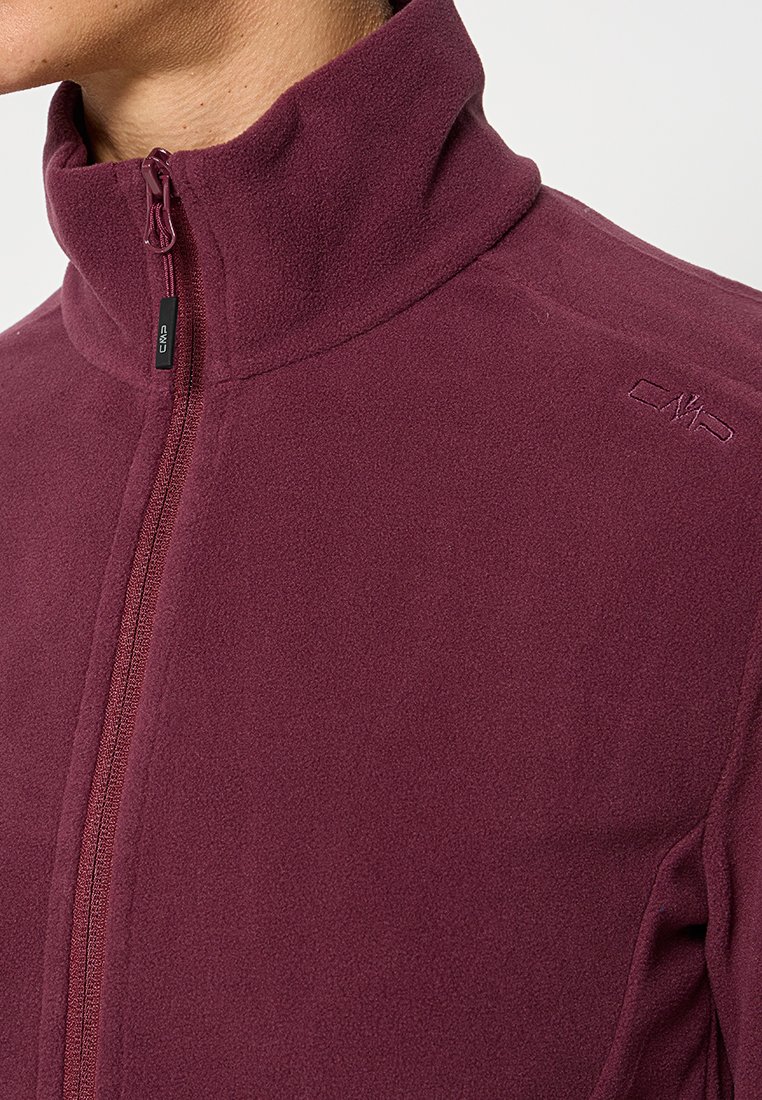 Burgunderfarbene Fleecejacke mit hohem Kragen, ausgestattet mit einem Reißverschluss und einem gestickten Logo auf der Schulter. Weiche Textur und taillierter Schnitt.