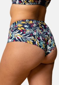 Bas de bikini fleuri avec un fond bleu marine et des motifs de feuilles et de fleurs multicolores, fabriqué à partir d'un matériau doux et extensible pour le confort.