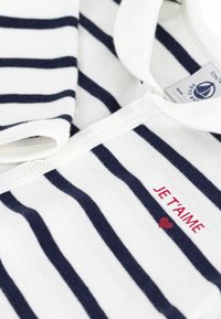 Ριγέ λευκό και ναυτικό βαμβακερό πουκάμισο με κουμπότρυπα, που φέρει το κείμενο "JE T'AIME" σε κόκκινο και μια μικρή κόκκινη καρδιά.