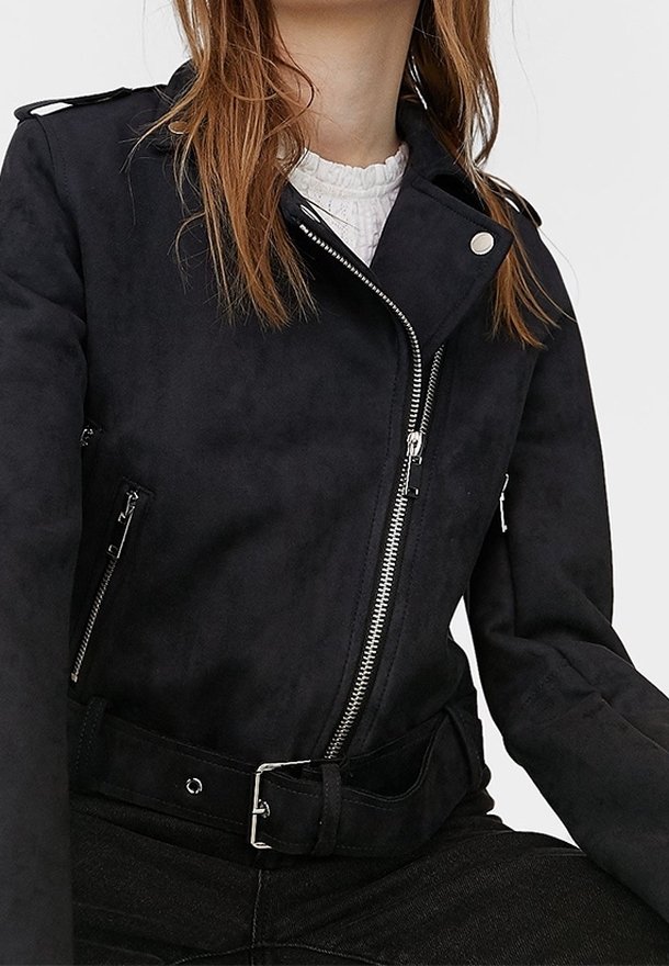 Giacca biker in finta suede nera con accessori in argento, tasche con cerniera e cintura regolabile. Dotata di colletto a risvolto e design aderente.