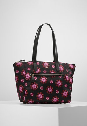 Sort tote taske med pink og rødt blomsterprint, to lange sorte håndtag og en forreste lynlåslomme på en hvid overflade.