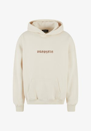 Cream-colored hoodie made of soft fabric, featuring a kangaroo pocket, ribbed cuffs, and a front graphic text design in brown.