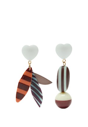 Asymetryczne kolczyki z białymi sztyftami w kształcie serca; jeden ma trzy wiszące elementy w kształcie paskowanych liści, drugi ma paskowaną owalną zawieszkę i półpaskowaną kulę.