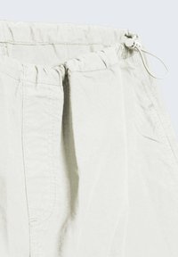 Helle graue Shorts mit elastischem Bund und Kordelzug, aus weichem Stoff gefertigt. Verfügt über ein gefälteltes Design und seitliche Taschen.