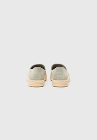 Suede grønne espadrillos med en naturlig jute sål, slip-on design, afrundet ryg og minimalistisk syning.