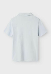 Ljust blå kortärmad polo skjorta med ribbat mönster och klassisk krage. Baksidan har en ren, sömlös design.