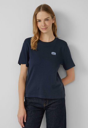 T-shirt en coton bleu marine avec un col rond, des manches courtes et un petit logo "CUTIE" brodé sur la poitrine dans des couleurs contrastées.