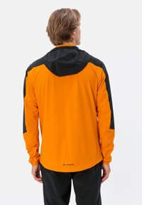 Giacca arancione e nera con maniche lunghe e cappuccio. Realizzata in tessuto leggero, presenta un logo sul retro vicino all'orlo.