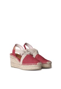 Punased kanvasest espadrillid, millel on beež risttugielement, jute-mähisega tald, ümarad varbad ja servade ääres õmmeldud detailid.