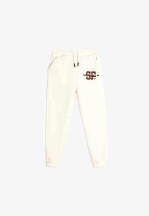 Weiße Sweatpants aus weichem Material, mit Seitentaschen, elastischen Bündchen und einem Druckdesign mit "SF California 1980" in dunkelrot.