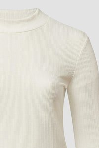 Geripptes Langarmshirt aus cremeweißem Stoff. Verfügt über einen hohen Kragen und eine figurbetonte Silhouette mit durchgehend vertikaler Struktur.