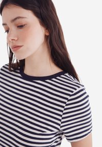 Marineblå og hvid stribet t-shirt med rund halsudskæring og korte ærmer, lavet af blødt bomuldsstof. Minimalistisk design uden yderligere detaljer.