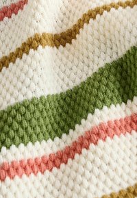 Texturierte Decke mit cremefarbenem Grund, die horizontale Streifen in Olivgrün, sanftem Rosa und Senfgelb aufweist. Strickmuster sichtbar.