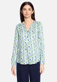 Langärmlige Bluse mit geometrischem Muster in Grün, Blau und Weiß, mit einem geschlitzten Ausschnitt und durchgehender Knopfleiste, in legerer Passform.
