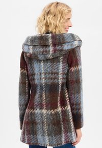 Wollmantel mit großer Kapuze, versehen mit einem mehrfarbigen Karo-Muster in Blau, Braun und Burgunder. Maßgeschneiderte Form mit einem ausgestellten Saum.