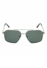 Lunettes de soleil aviateur à monture métallique argentée, verres vert foncé et branches à embouts noirs sur fond blanc.