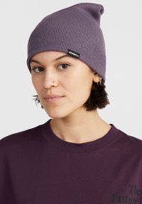 Lilla strikket hue med et let slouchy design og et sort mærke, der har teksten "ONEILL." Bæres med en mørkelilla sweatshirt.