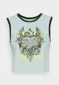 Ljusblå ärmlös crop top med mörkgrön kant, prydd med intrikata svarta blommor och kronmönster, guldfärgad nitar och gul text som säger "Venus Rising."