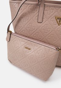 Borsa a tracolla sintetica beige trapuntata con motivo logo in rilievo e hardware dorato. Include una pochette più piccola staccabile con zip.
