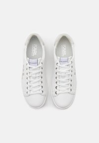 Baskets en cuir blanc avec bouts ronds, lacets plats et œillets argentés. Présentent un logo embossé sur le côté et une texture lisse.