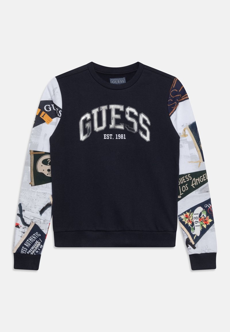 Sweat-shirt noir avec l'inscription "GUESS EST. 1981" en grandes lettres sur le devant, doté de manches à motifs patchwork graphiques multicolores.