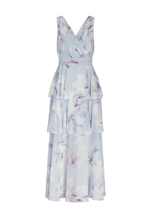 Vestido de tela azul claro con estampado floral, con escote en V, diseño en capas y suaves pliegues. Presenta flores grandes en blanco y morado.