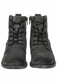 Botines de ante negro con cierre de cordones y cremallera, que cuentan con una suela de goma plana y una textura suave. Diseño simple sin patrones visibles.