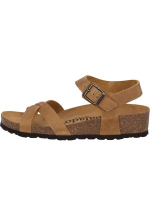 Brown suede sandal with cross straps, adjustable ankle buckle, cork midsole, and textured rubber outsole. Flat heel.