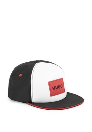 Zwart-wit pet met een rode rechthoekige patch met het label "HUGO." Heeft een vlakke rand, contrasterende stiksels en een rode accent op de rand.