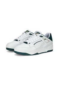 Weiße Sneakers mit grünen Akzenten, aus strukturiertem Lederoberteil, weißen Schnürsenkeln und dämpfender Sohle. Das Design umfasst Seitenpaneele und Perforationen.
