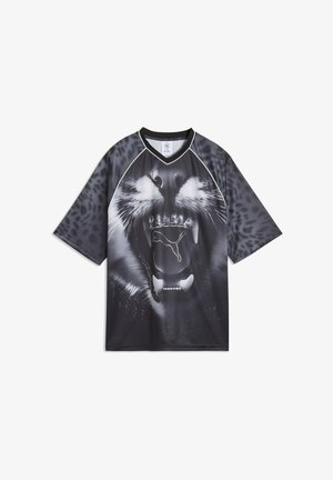 Camiseta gráfica negra con el rostro de un león, destacado por un logotipo brillante de "PUMA", con una textura lisa y suave y mangas cortas.