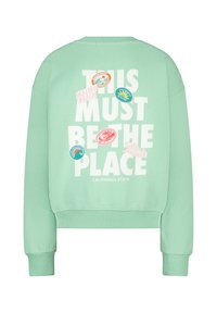 Felpa oversize verde menta con testo bianco e numerosi patch grafici colorati sul retro, con vita e polsini a coste.