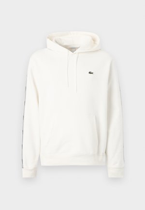 Bela kapuca s sprednjim žepom kanguru, kapuco z vrvico za zategovanje, trak z blagovno znamko ob rokavih in majhno zeleno krokodilovo logotipom na prsih.