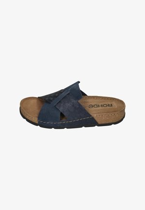 Navy slide sandal featuring crossband design, cork footbed, textured fabric, and rubber sole with stitching detail.